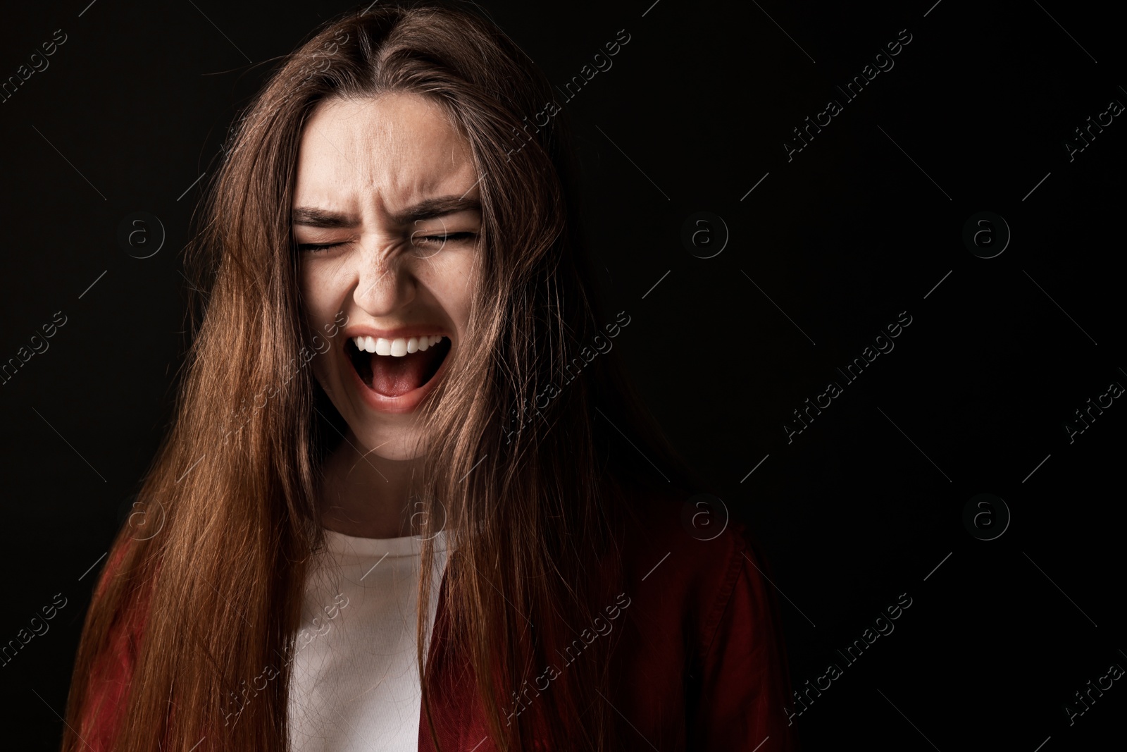 Photo of Portrait of scared woman on black background. Space for text