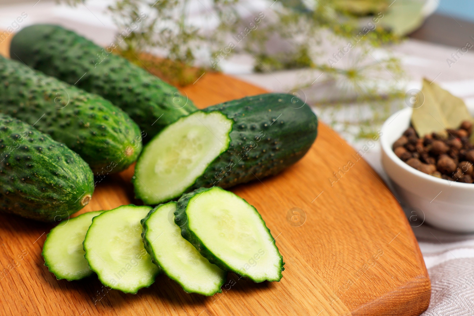 Photo of Fresh whole and cut cucumbers on table, closeup