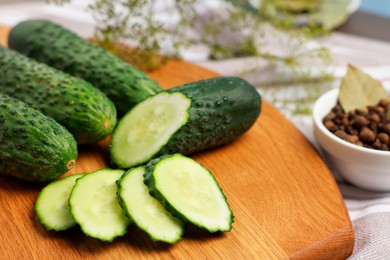 Photo of Fresh whole and cut cucumbers on table, closeup