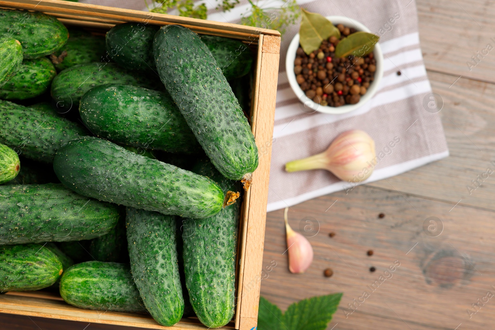 Photo of Fresh green cucumbers and spices on wooden table, flat lay