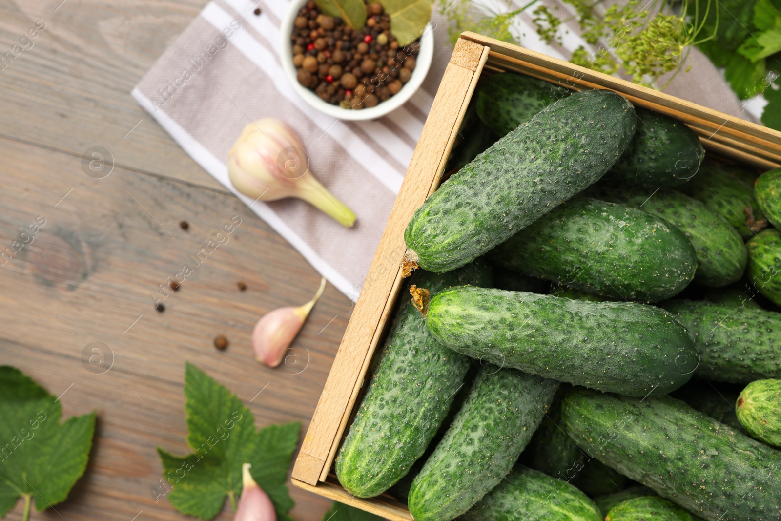 Photo of Fresh green cucumbers and spices on wooden table, flat lay