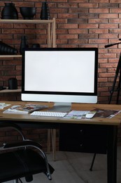 Photo of Computer and magazines on wooden table in photo studio