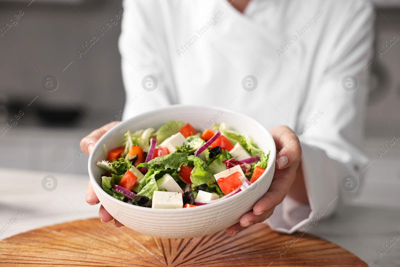 Photo of Professional chef with delicious salad in kitchen, closeup