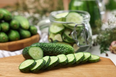 Board with fresh cut cucumber on table, closeup