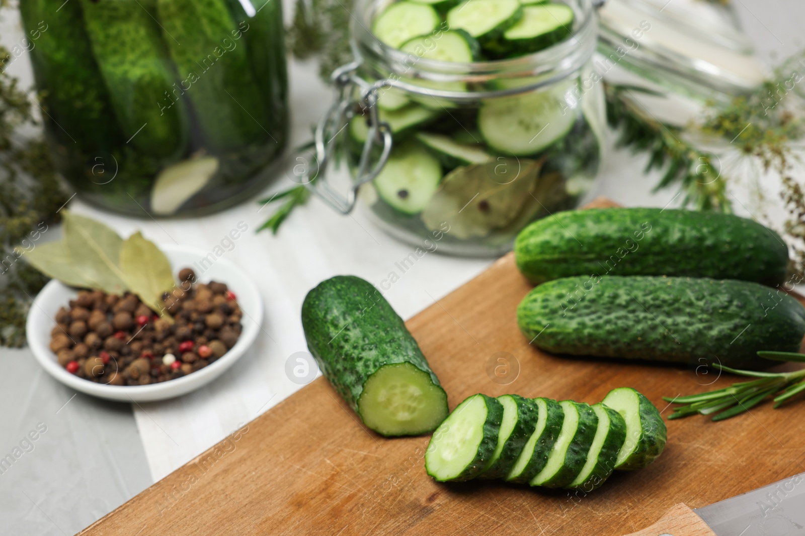 Photo of Fresh cucumbers and spices on light table, closeup. Preparation for pickling