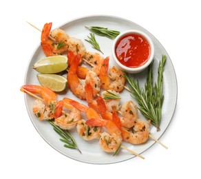 Photo of Skewers with delicious grilled shrimps, lime and sauce isolated on white, top view