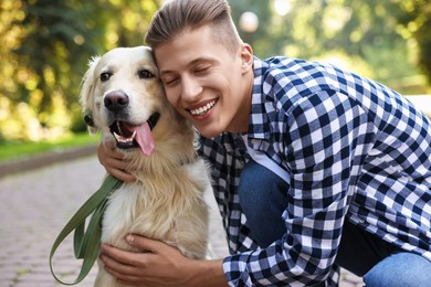 Portrait of happy owner with cute Golden Retriever dog outdoors