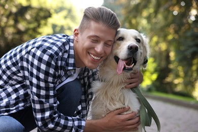 Portrait of happy owner with cute Golden Retriever dog outdoors