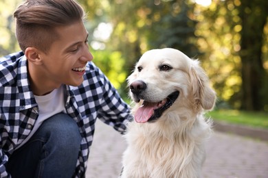 Portrait of happy owner with cute Golden Retriever dog outdoors