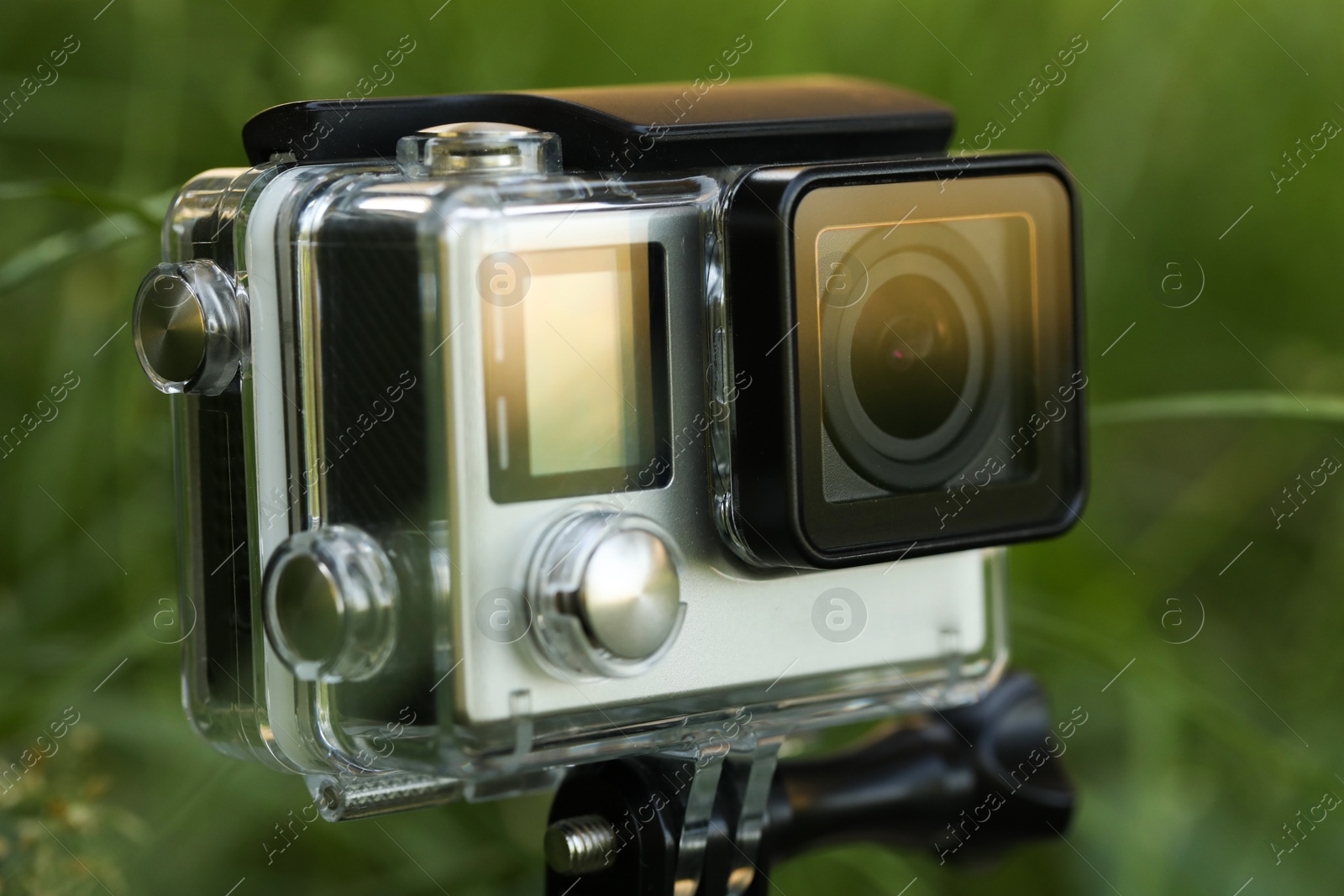 Photo of Modern action camera in grass outdoors, closeup