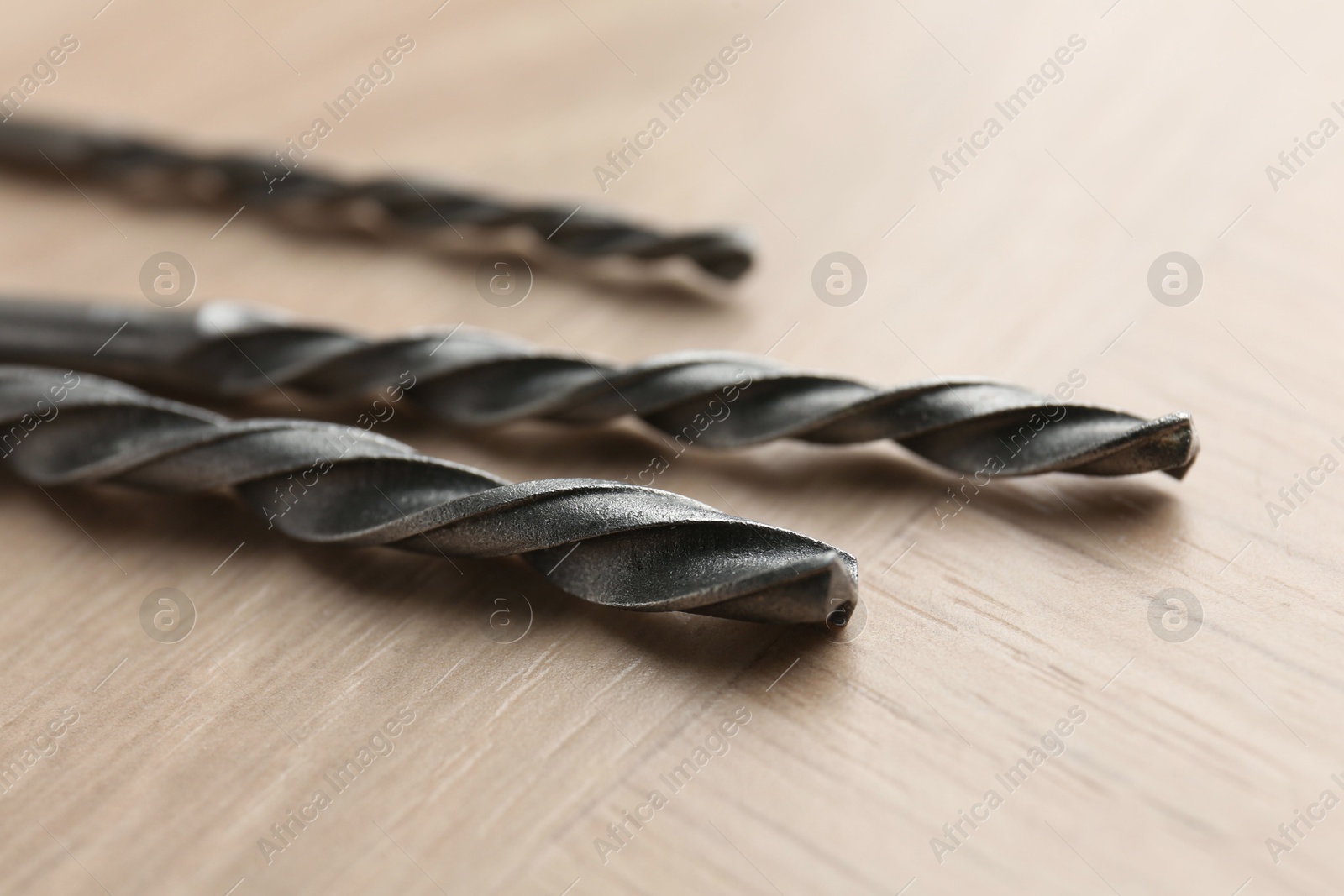 Photo of Different drill bits on wooden surface, closeup