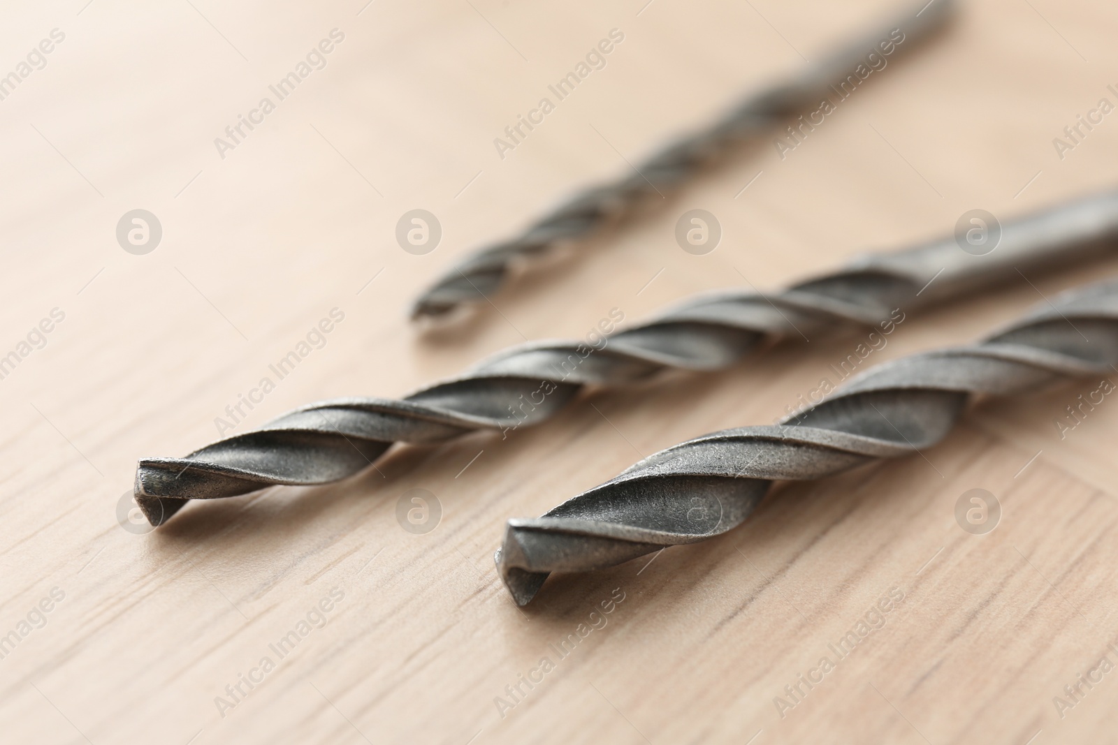 Photo of Different drill bits on wooden surface, closeup