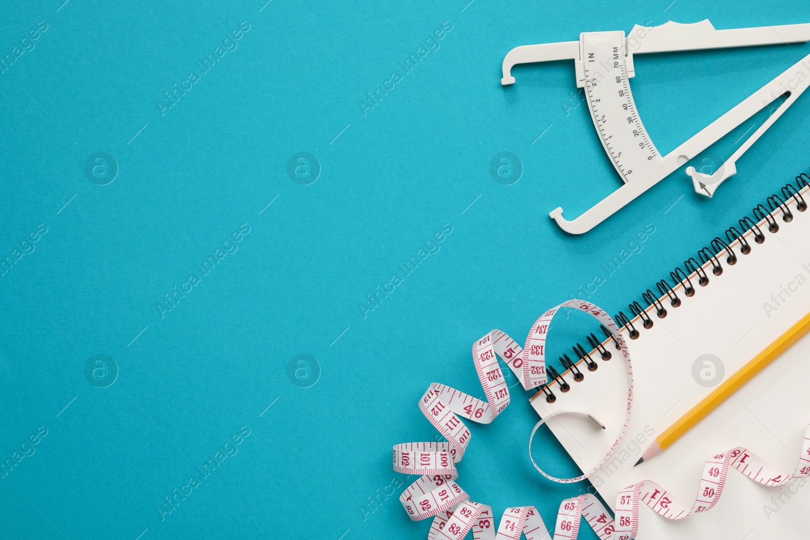 Photo of Body fat caliper, measuring tape, notebook and pencil on light blue background, flat lay. Space for text