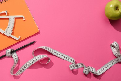 Photo of Body fat caliper, measuring tape, notebook and apple on pink background, flat lay. Space for text