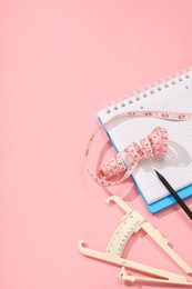 Photo of Body fat caliper, measuring tape, notebook and pencil on pink background. Space for text