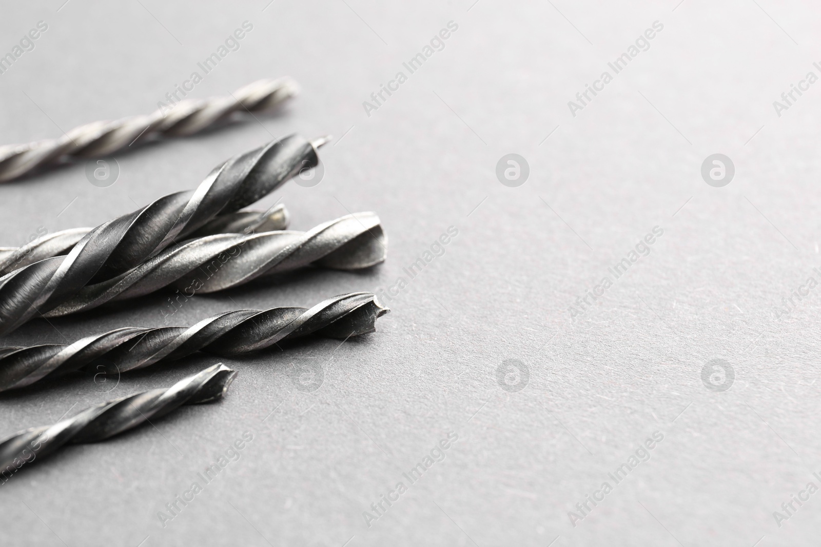 Photo of Many different drill bits on light grey table, space for text