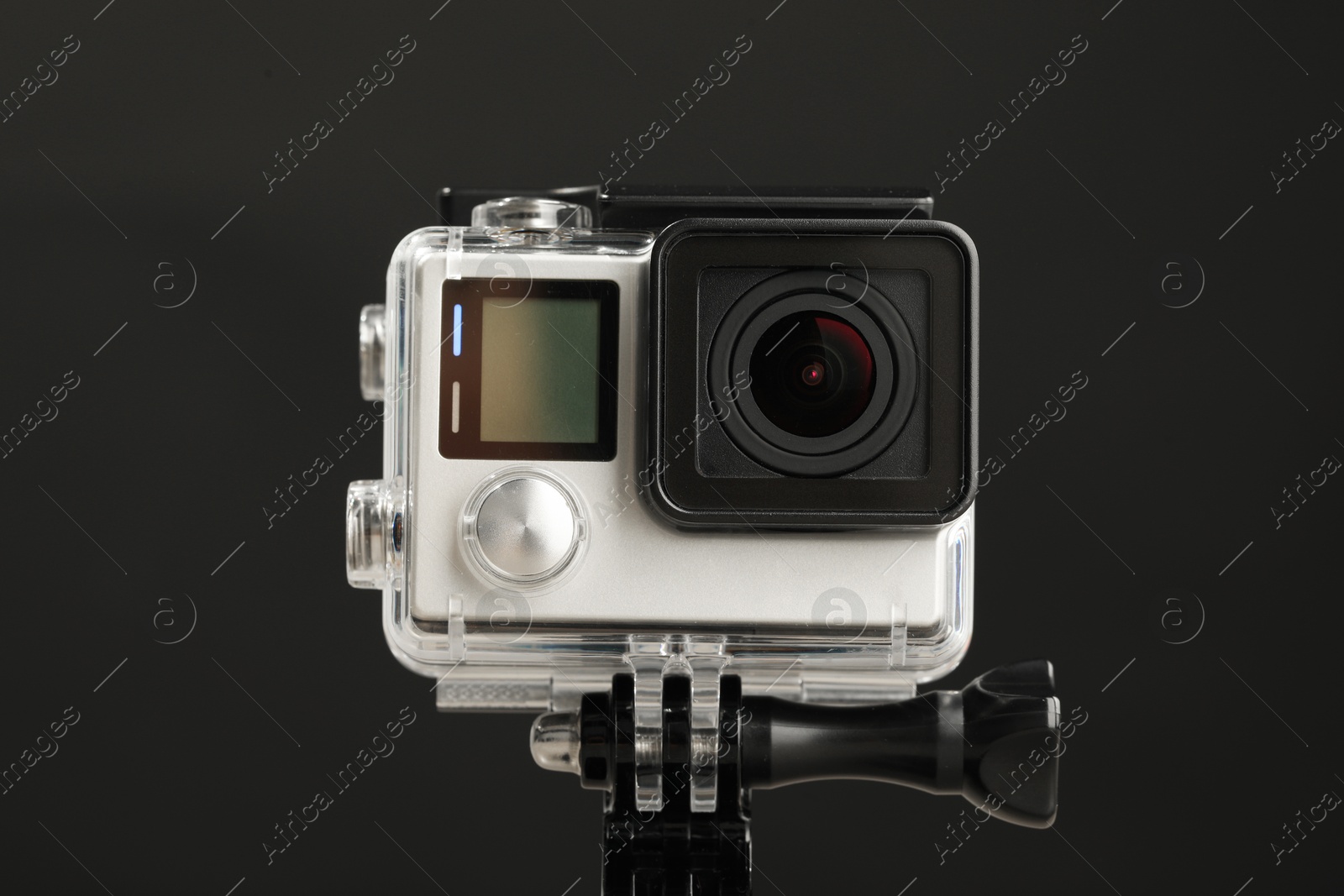 Photo of Modern action camera and mount against black background, closeup