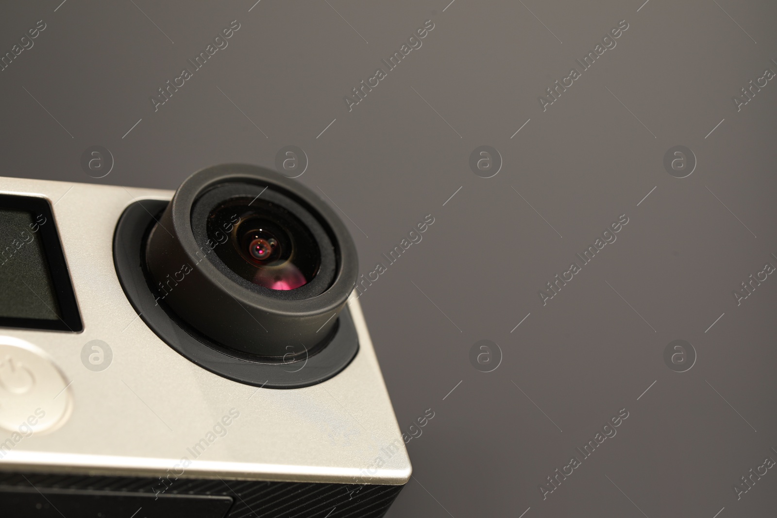 Photo of Modern action camera on grey background, closeup. Space for text