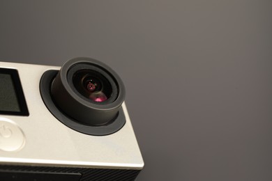 Modern action camera on grey background, closeup. Space for text