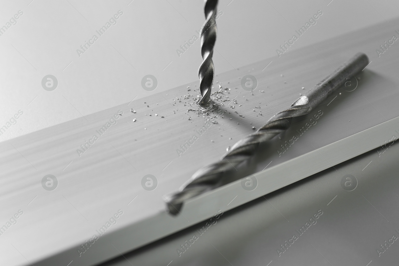 Photo of Drilling hole in plank on light table, closeup