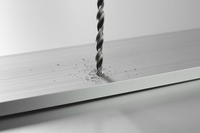 Photo of Drilling hole in plank on light table, closeup