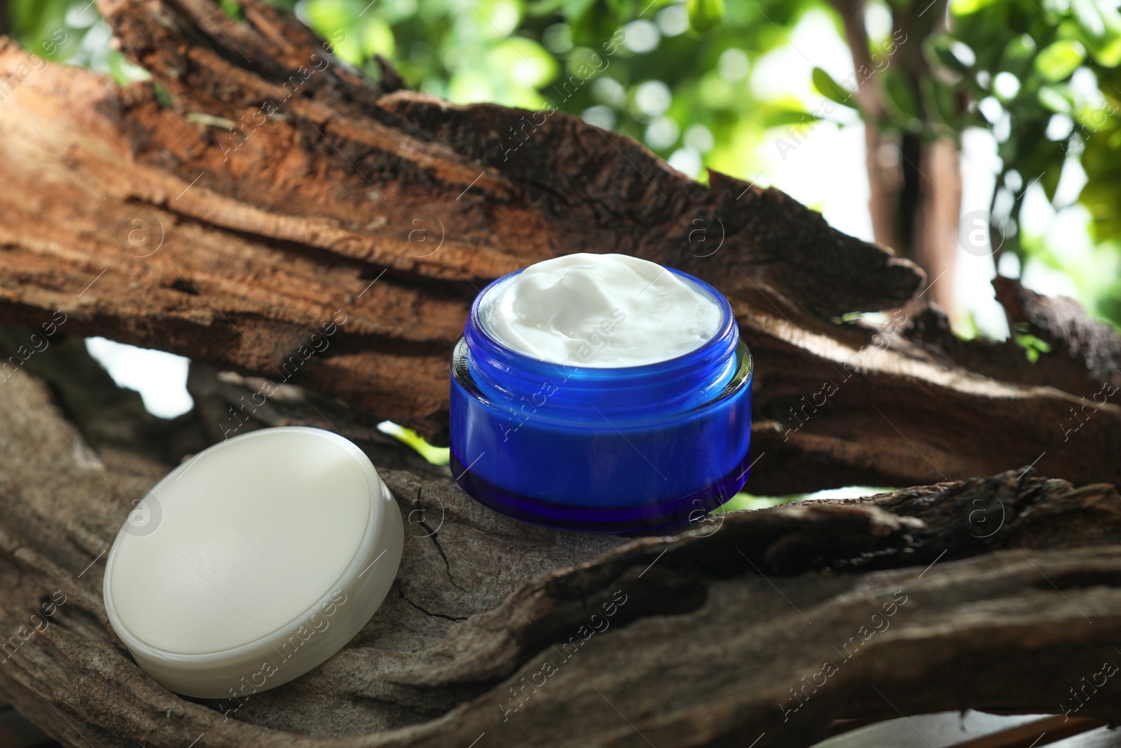 Photo of Stylish presentation of facial cream in jar outdoors