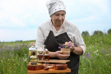 Senior woman with mortar and pestle making tincture outdoors