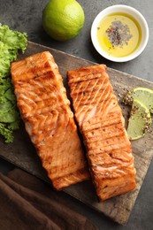 Delicious grilled salmon fillets served on grey table, flat lay