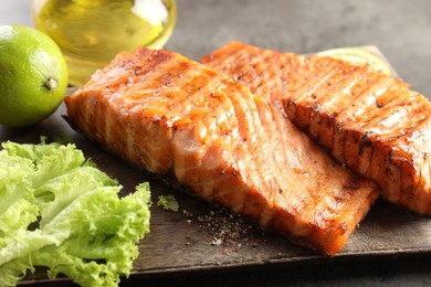 Photo of Delicious grilled salmon fillets served on grey table, closeup