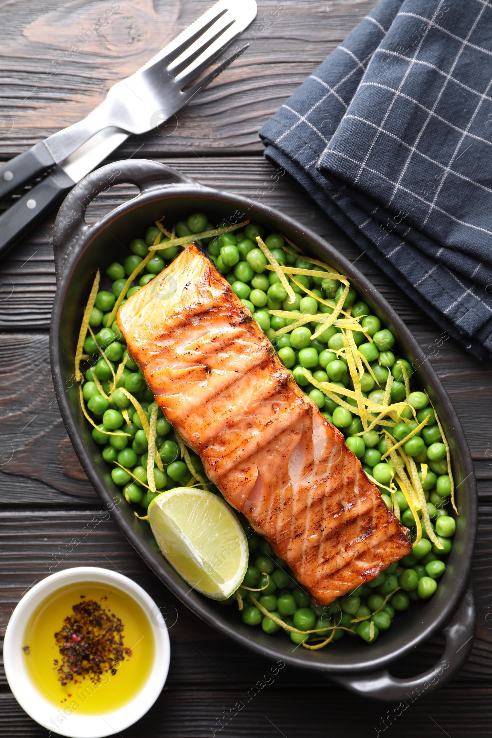 Photo of Delicious grilled salmon fillet in baking dish served on wooden table, flat lay