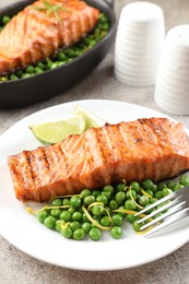 Photo of Delicious grilled salmon fillet served on grey textured table