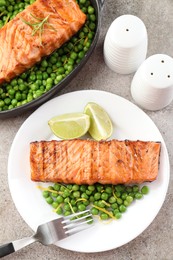 Photo of Delicious grilled salmon fillets served on grey textured table, flat lay