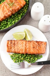 Photo of Delicious grilled salmon fillets served on grey textured table, flat lay