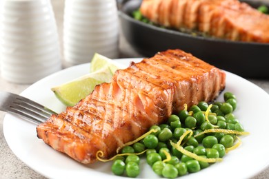 Delicious grilled salmon fillets served on grey table, closeup