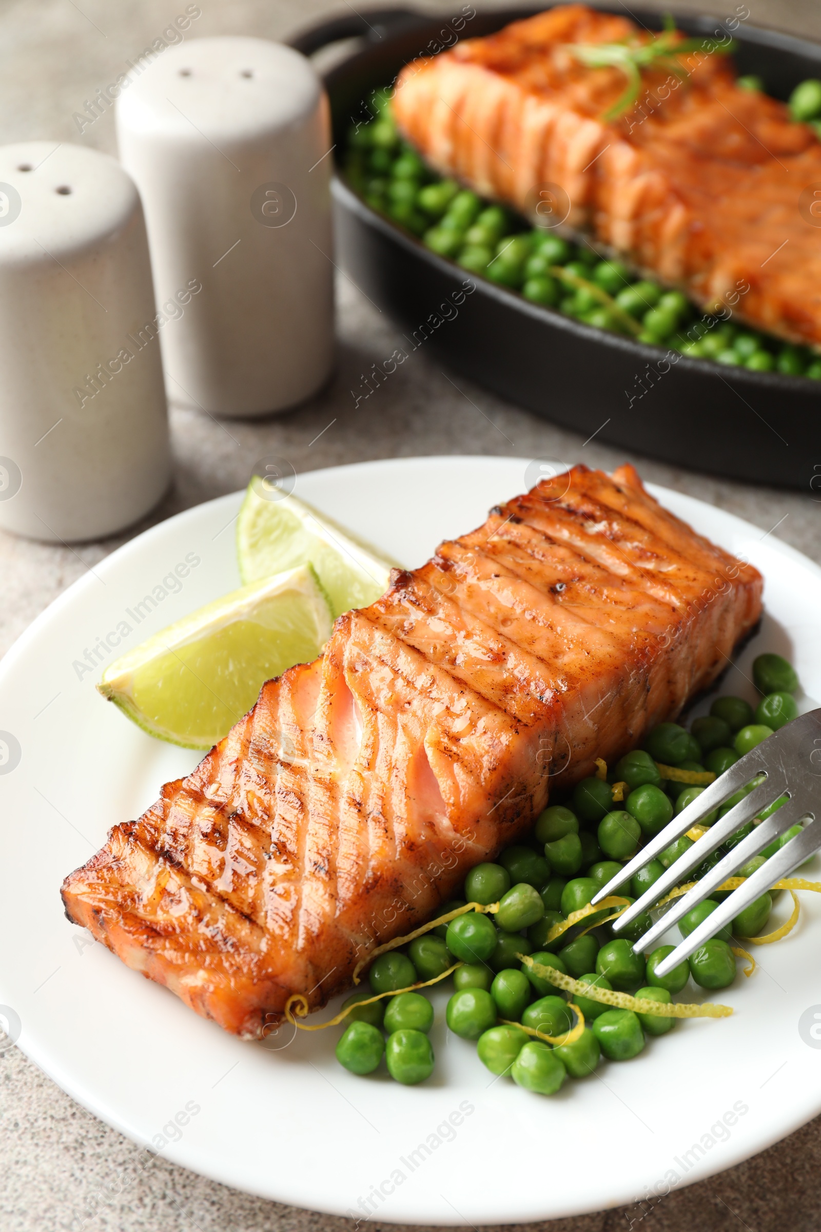 Photo of Delicious grilled salmon fillet served on grey table, closeup