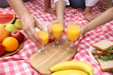 Photo of Family having picnic on checkered blanket outdoors, closeup