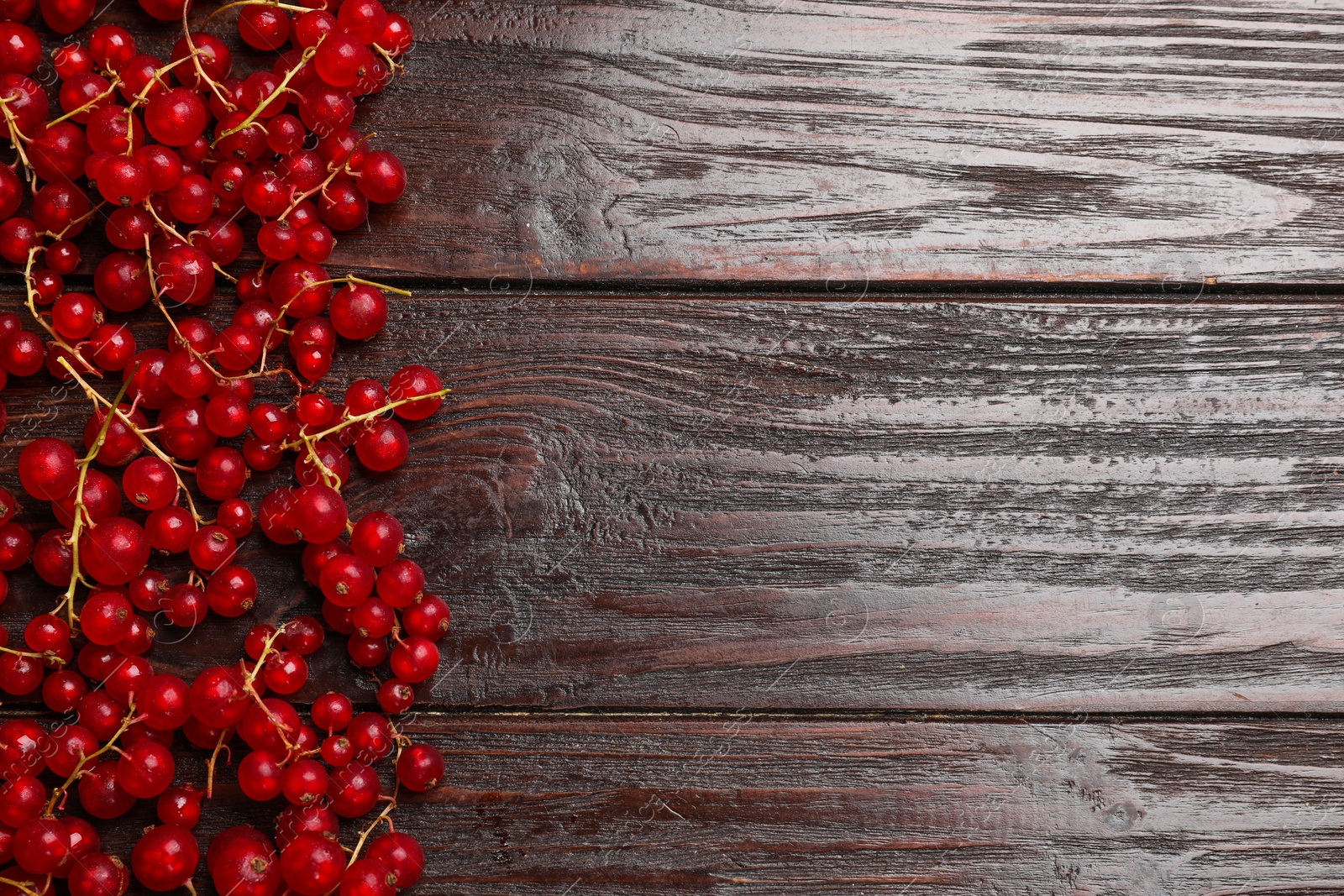 Photo of Fresh red currants on wooden table, top view. Space for text