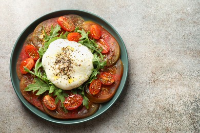 Delicious fresh burrata salad in bowl on gray textured table, top view. Space for text