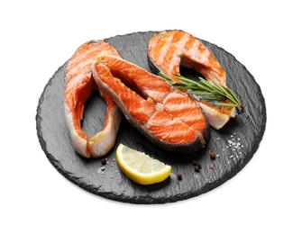 Photo of Tasty grilled salmon steaks, lemon and spices isolated on white