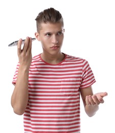 Young man with smartphone listening to voice message on white background