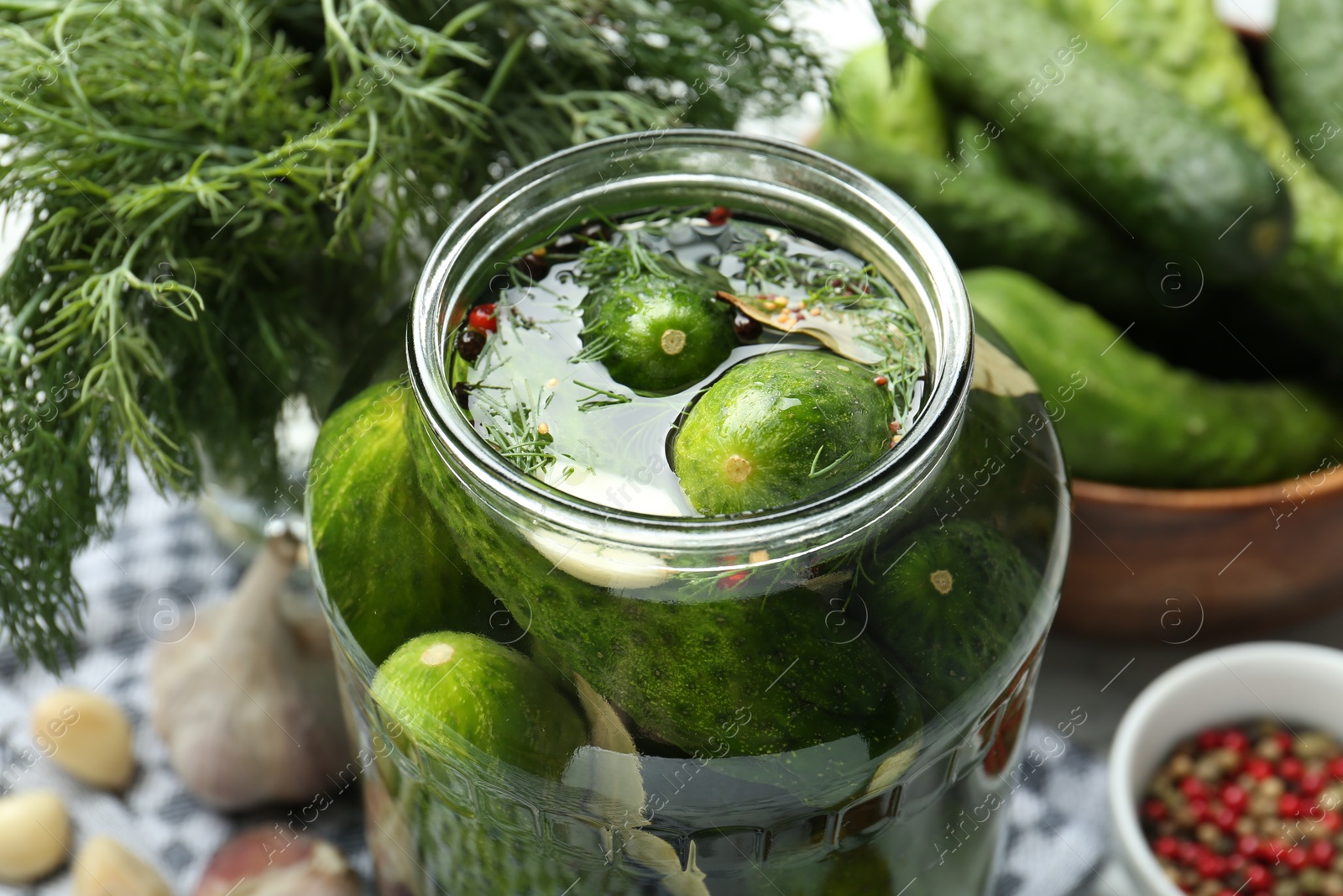 Photo of Making pickles. Fresh cucumbers and spices in jar on table, closeup