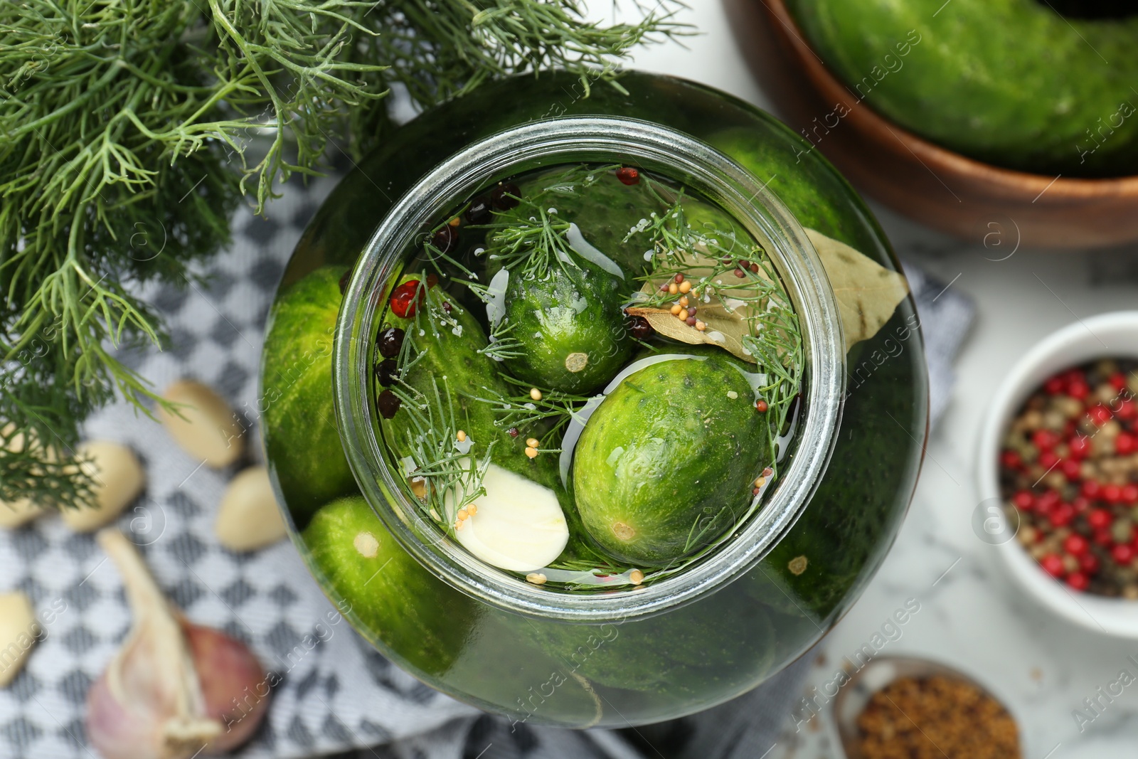 Photo of Making pickles. Fresh cucumbers and spices in jar on table, top view