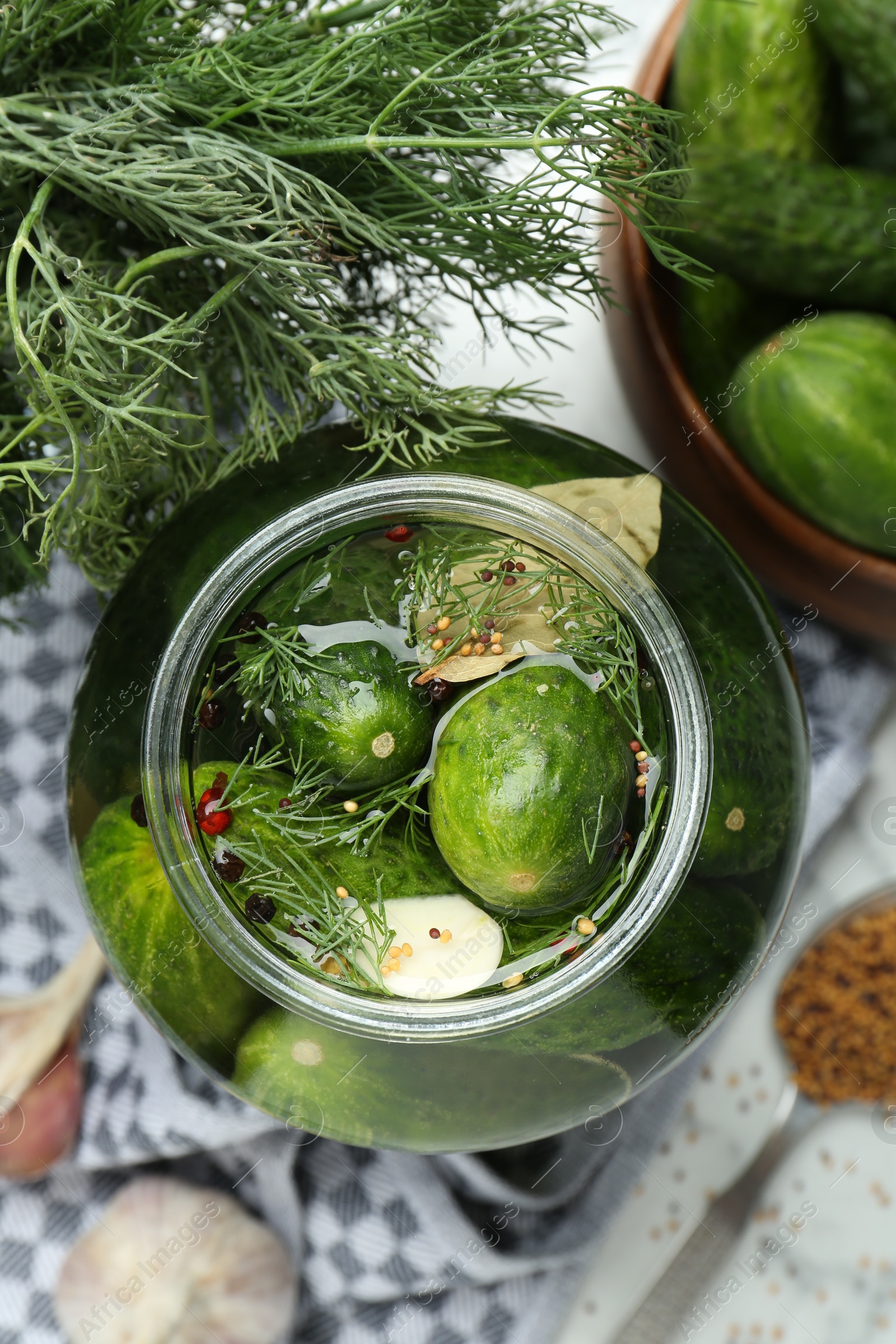 Photo of Making pickles. Fresh cucumbers and spices in jar on table, top view