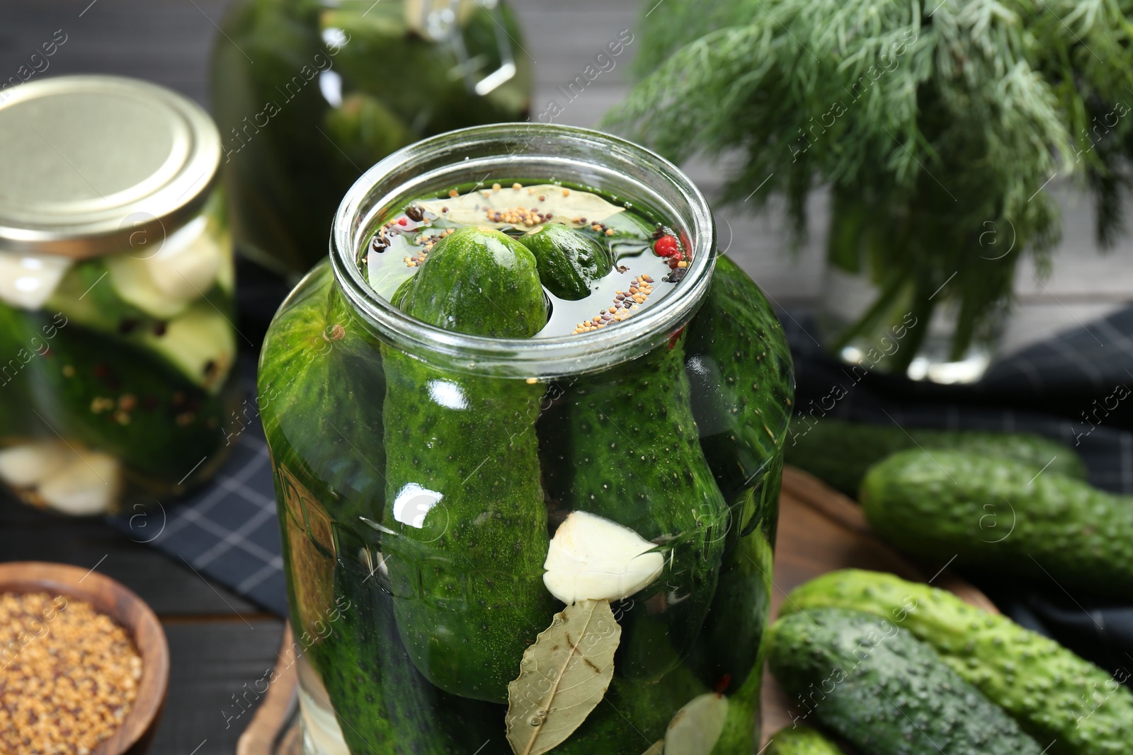 Photo of Making pickles. Fresh cucumbers and spices in jar on table, closeup