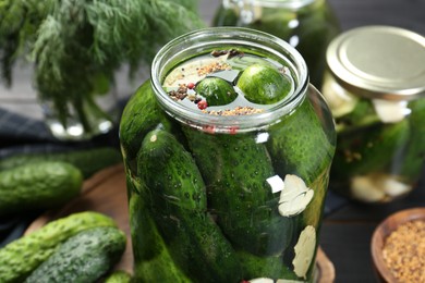 Photo of Making pickles. Fresh cucumbers and spices in jar on table, closeup