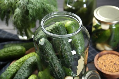 Photo of Making pickles. Fresh cucumbers in jar on table, closeup