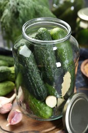 Photo of Making pickles. Fresh cucumbers and spices in jar on table, closeup