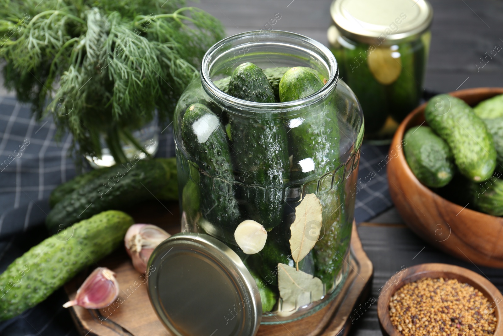 Photo of Making pickles. Fresh cucumbers and spices in jar on table, closeup