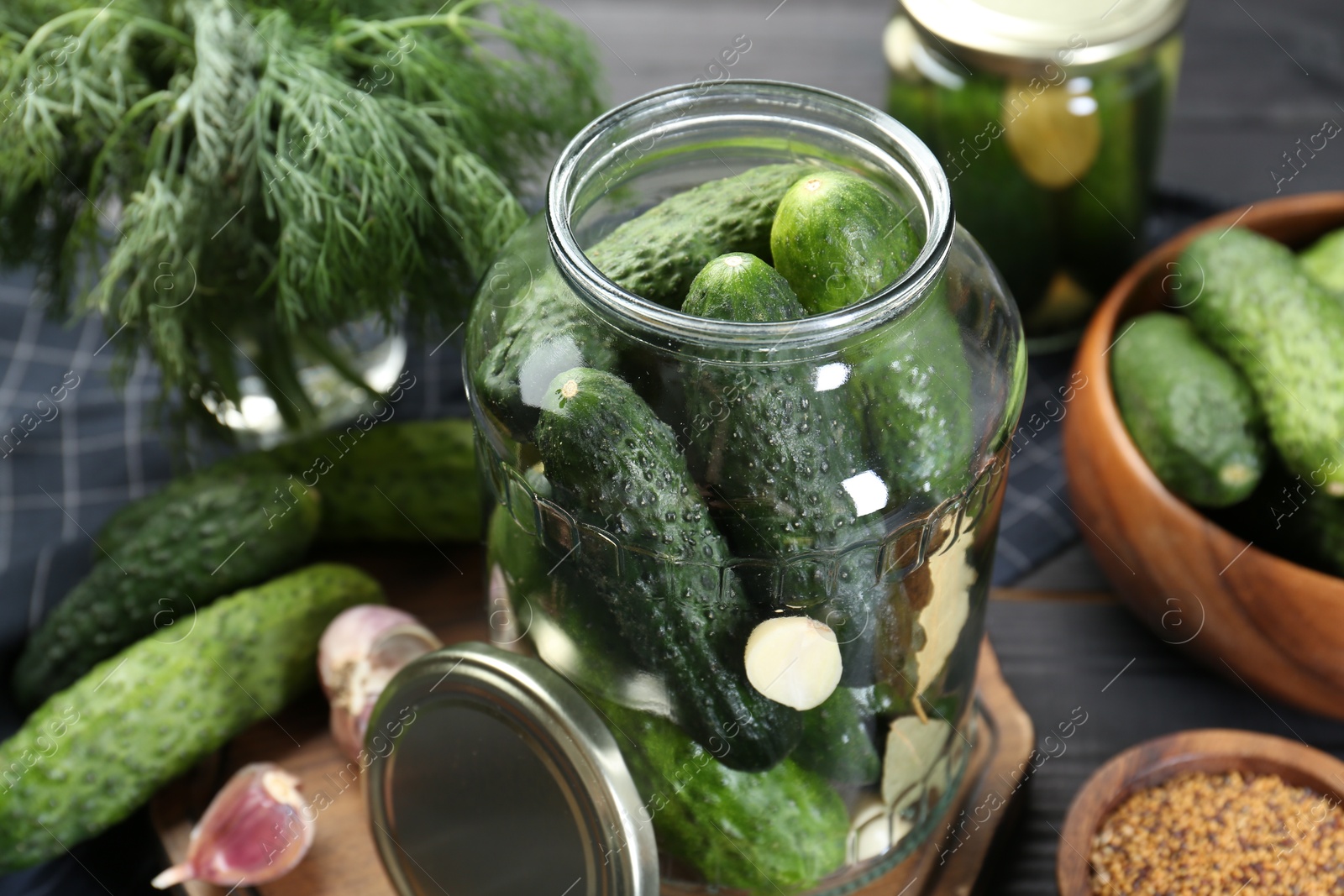 Photo of Making pickles. Fresh cucumbers and spices in jar on table, closeup