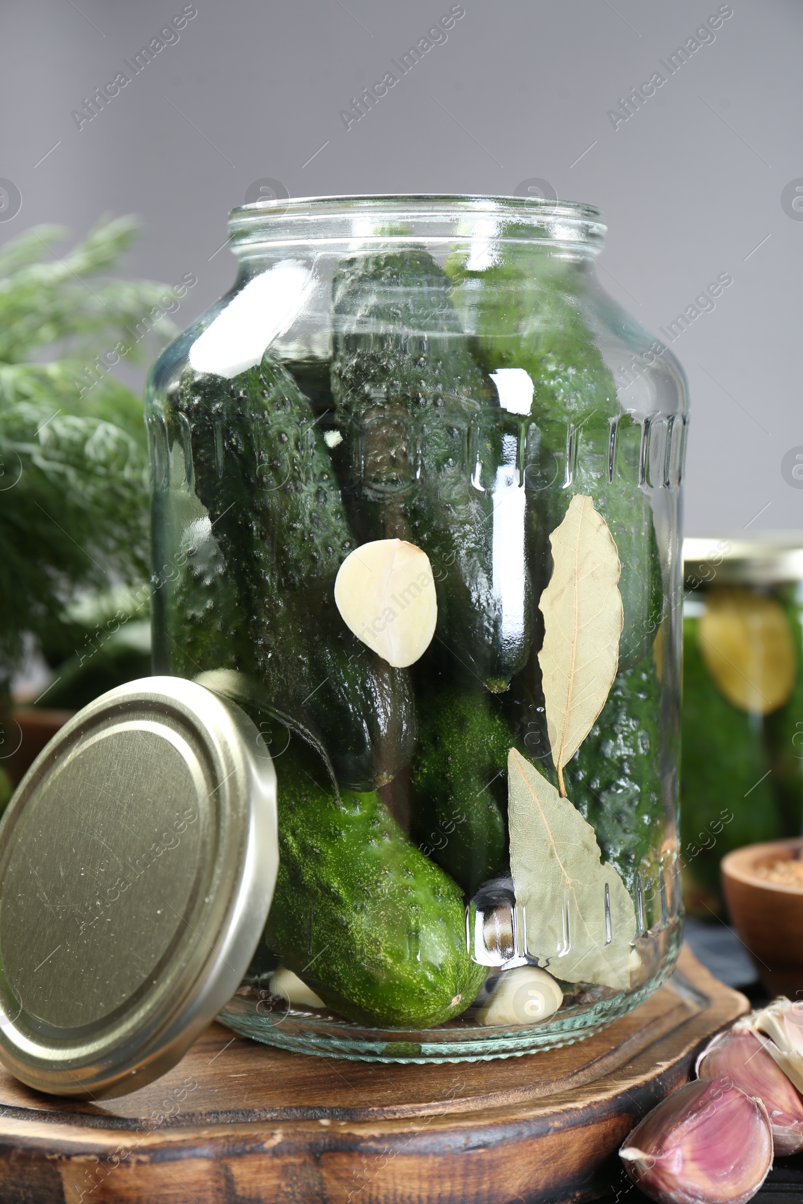 Photo of Making pickles. Fresh cucumbers and spices in jar on table